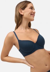 Sujetador azul marino con textura acanalada, soporte con aros y borde decorativo de encaje a lo largo de los bordes y tirantes. Incluye tirantes ajustables.