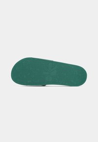 Suola di scarpa in gomma verde con superficie testurizzata, impronta del logo e intricato motivo di battistrada per una migliore presa e trazione.