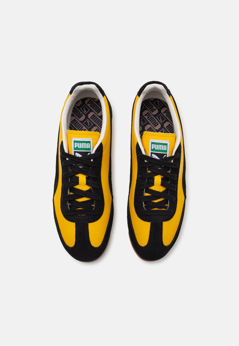 Baskets à lacets avec une tige en textile jaune et des accents en daim noir. Présentent un bout rond, un col rembourré et une semelle extérieure en caoutchouc.