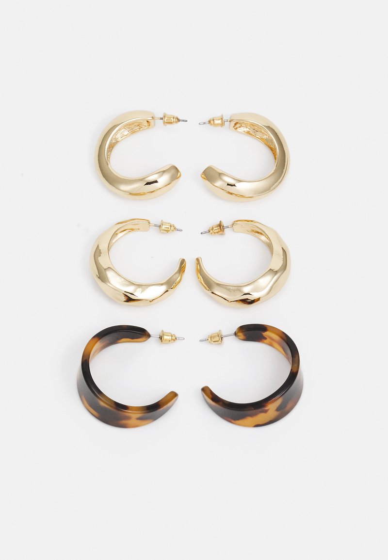 Ensemble de trois paires de boucles d'oreilles créoles : deux paires en métal doré avec des surfaces lisses et brillantes, et une paire en écaille de tortue avec une finition brillante.