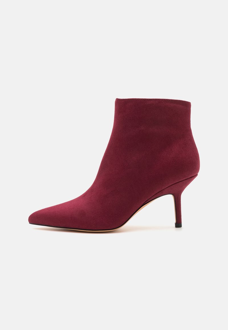 Bottine femme en daim bordeaux avec bout pointu et talon aiguille fin de hauteur moyenne sur fond blanc.