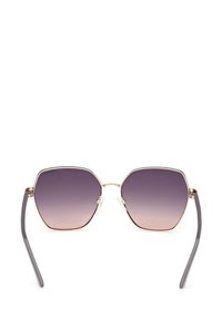 Hexagonální sluneční brýle se zlatým kovovým rámem, tmavě až světle gradientními skly a šedými ramínky. Obsahují nastavitelné průhledné nosní podložky.