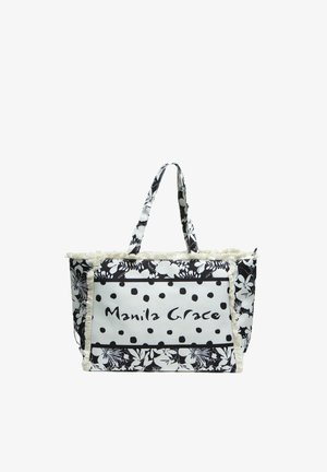 Borsa tote nera e bianca con motivi floreali e a pois, bordi con frange e scritta "Manila Grace" sulla tasca frontale.