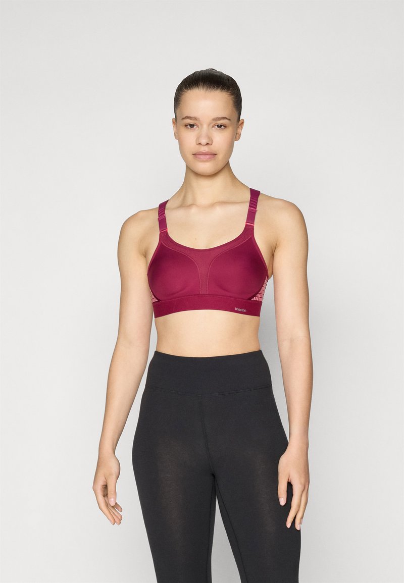 Maron sports-bh med en glatt tekstur, brede stropper og en strukturert design. Kombinert med svarte høytaljede leggings.