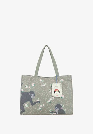 Sac cabas gris avec deux singes noirs et de petites fleurs blanches, avec une étiquette Frida Kahlo attachée à la poignée.
