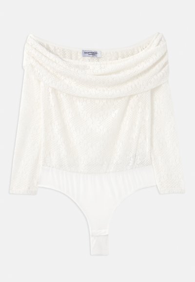 Hvit blondebodi med off-shoulder hals, trekvartlange ermer og en glattere bunnpanel. Har intrikate blomstermønstre.