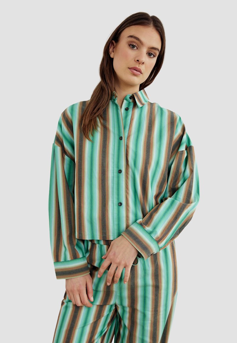 Green and brown striped button-up shirt with a cropped design, long sleeves, and black buttons. Made of smooth, lightweight fabric.