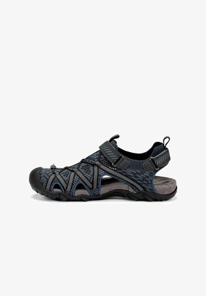 Sandalia negra y gris con parte superior de malla transpirable, correas ajustables, suela texturizada y puntera protectora para actividades al aire libre.