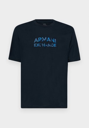 T-shirt in cotone blu navy con collo rotondo, caratterizzato da un logo ricamato blu lucido "ARMANI EXCHANGE" al centro. Maniche corte, vestibilità comoda.