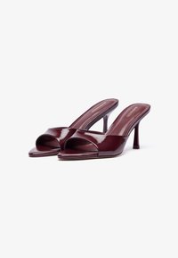 Μαρέν παπούτσια mules από πατεντάριστο δέρμα με ανοιχτό μπροστινό μέρος, φαρδύ λουρί στο μπροστινό μέρος και καμπυλωτό τακούνι 4 ιντσών, με απαλό, γυαλιστερό φινίρισμα.