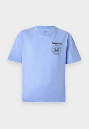 T-shirt de algodão azul claro com mangas curtas, decote redondo e impressão do logotipo preto "Ramones" na área do peito esquerdo. Textura suave.