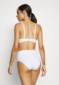 White bra and high-waisted underwear set. Smooth fabric, adjustable straps, and a classic cut design with clean lines. No visible patterns.