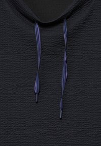 Svart texturerad hoodie med en frontkrage som har lila randiga dragsko och svarta plastspetsar.