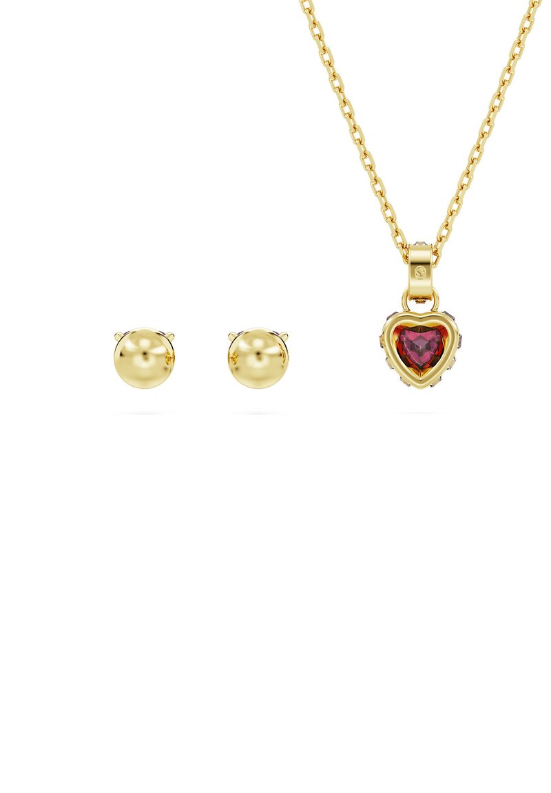 Goldkette mit einem herzförmigen roten Edelsteinanhänger, begleitet von zwei runden goldfarbenen Steckerohrringen. Die Kette hat ein klassisches Gliederdesign.