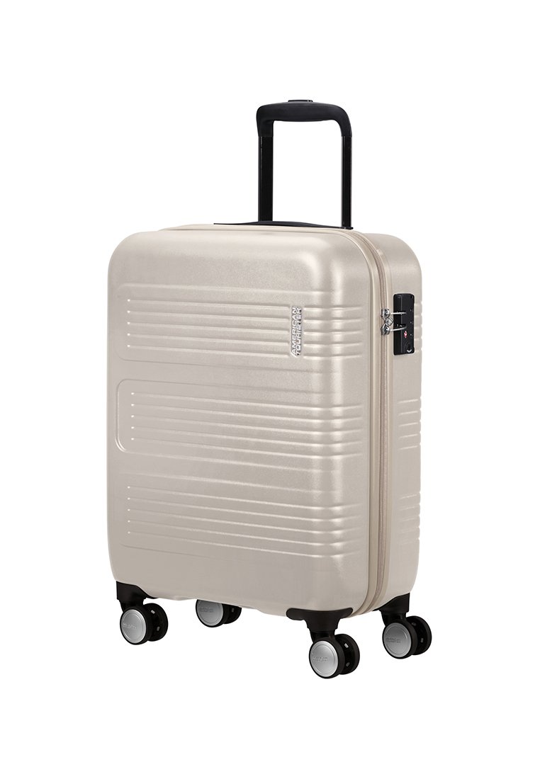 Valise rigide, dorée métallisée, finition texturée avec des rainures horizontales, poignée rétractable noire, quatre roues noires, cadenas à combinaison.