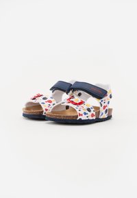 Gyerek szandál fehér alappal, színes halmintákkal. Két sötétkék tépőzáras pánt, parafa talpbetét és texturált fekete talp.