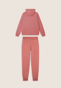 Chándal de algodón rosa que incluye una sudadera con capucha y puños acanalados, y pantalones de chándal a juego con una cinturilla elástica y detalles de logo.