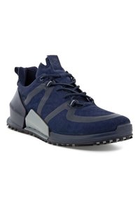 Chaussure de sport bleu marine avec des accents noirs et gris, fermeture à lacets, semelle texturée et col rembourré pour un soutien de la cheville.