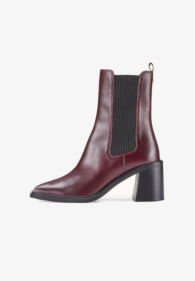 Bottine en cuir bordeaux à bout pointu, avec panneaux élastiques noirs sur les côtés, talon bloc et languette à l'arrière.
