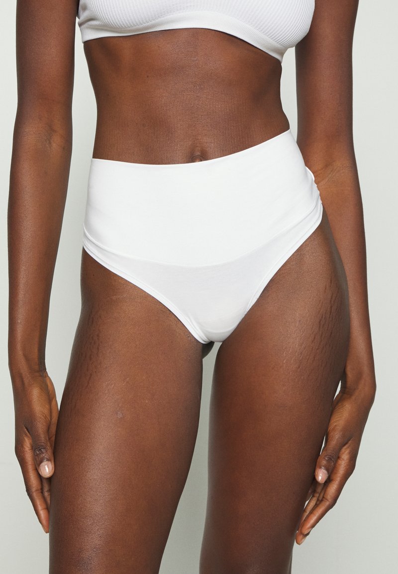 Högmidjade vita bikiniunderkläder i mjuk bomull, med en slät yta och en klassisk design med subtila sömdetaljer.