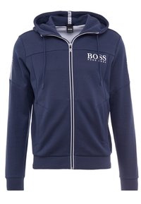 Marinblå zip-hoodie med en texturerad övre del, en vit logotyp på bröstet, framfickor och ribbade ärmslut och nederkant.