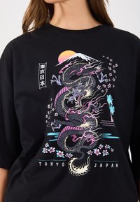 Tricou negru cu un grafic colorat de dragon. Designul include Muntele Fuji, flori de cireș și textul "Tokyo Japonia" în partea de jos.