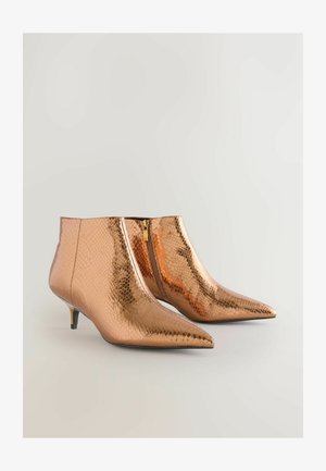 Botas de tobillo de bronce con textura de estampado de serpiente, con puntera afilada y un tacón bajo y cónico, sujetas con una cremallera lateral.