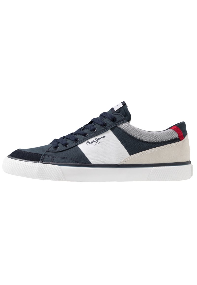 Tenisky s kombinací tmavě modré plátno, bílé látky a béžové semišové kůže. Gumová podrážka, kulatá špička, závazné přední šněrování a kontrastní červený akcent.