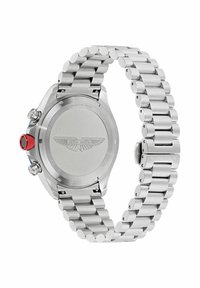 Kerge harjatud pinnaga roostevabast terasest kell, ümmargune kellanäidik, punane aktsent kroonil ja segmenteeritud käevõru stiil. Tagaküljel on graveeritud logo.