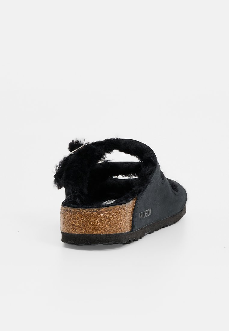 Sandalo a scivolo in suede nero con rivestimento morbido, suola intermedia in sughero e suola in gomma. Design minimalista con retro aperto e tacco leggero.