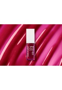 Lippenöl in einer rechteckigen Glasflasche mit einem weißen Deckel; tiefrosa Flüssigkeit vor einem glänzenden rosafarbenen Hintergrund mit erhöhten Rillen.