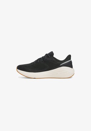 Chaussure de course noire avec une tige en mesh respirant, surface texturée, semelle intermédiaire blanche et semelle extérieure en caoutchouc caramel. Elle possède des lacets et un logo.
