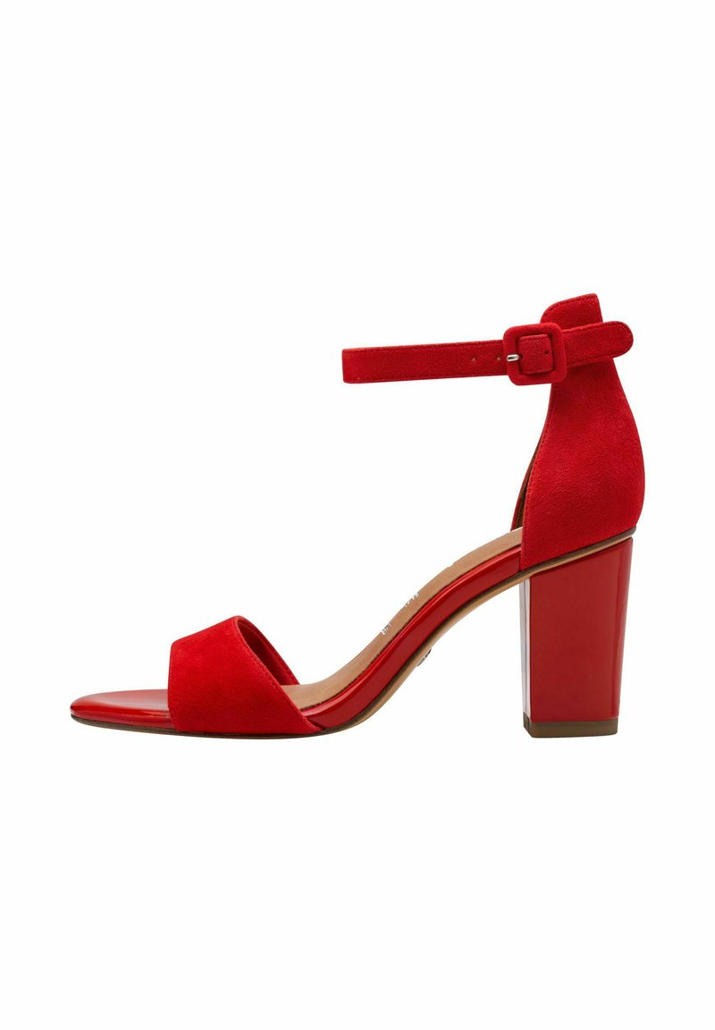 Red suede high-heeled sandal with a peep toe, ankle strap, and a chunky heel. Smooth, shiny sole accentuates the textured upper.