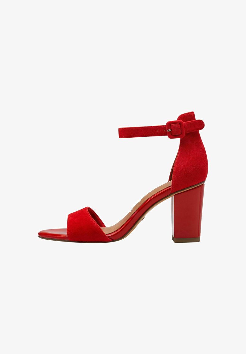 Rote Wildledersandalen mit hohen Absätzen, offenem Zehenbereich, Knöchelriemen und einem stabilen Absatz. Die glatte, glänzende Sohle hebt das strukturierte Obermaterial hervor.