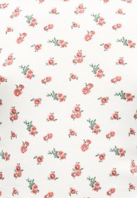 Λευκό ύφασμα με σχέδιο μικρών συστάδων από ροζ τριαντάφυλλα και πράσινα φύλλα, ομοιόμορφα κατανεμημένα σε όλη την επιφάνεια.