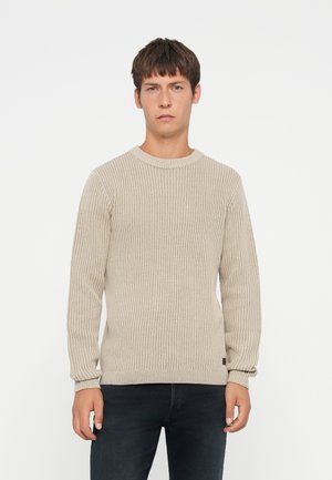 Beige ribbelgebreide trui met een ronde halslijn en lange mouwen, voorzien van een aansluitende zoom en een subtiele logotag aan de onderzijde.