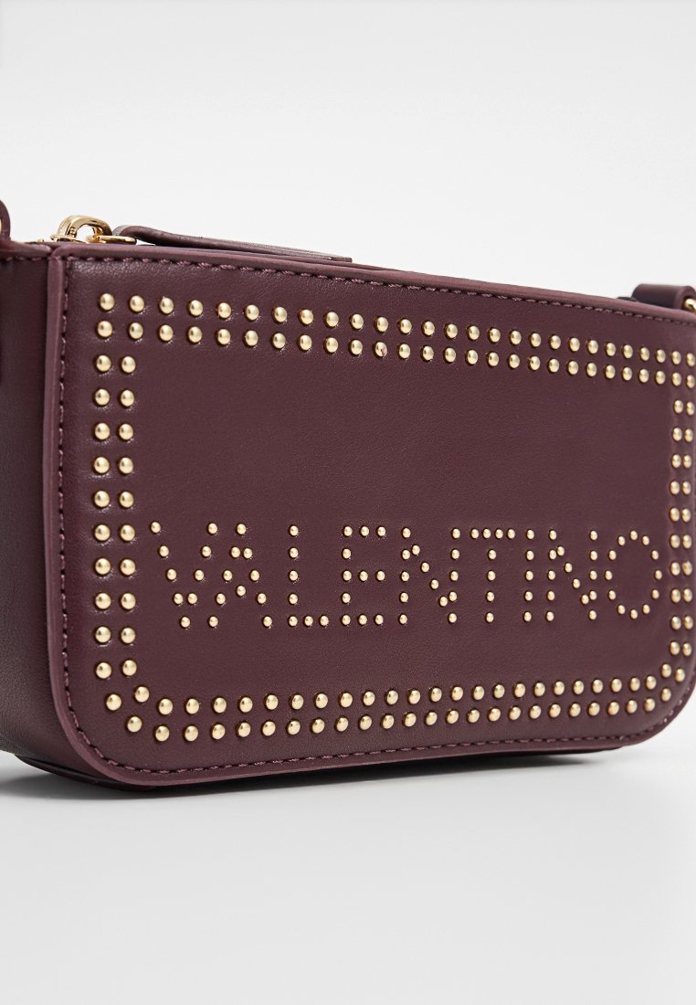 Burgunderfarbene Leder-Umhängetasche mit goldenen Nieten und eingeprägtem "VALENTINO"-Schriftzug auf der Vorderseite, rechteckige Form, kompaktes Design.