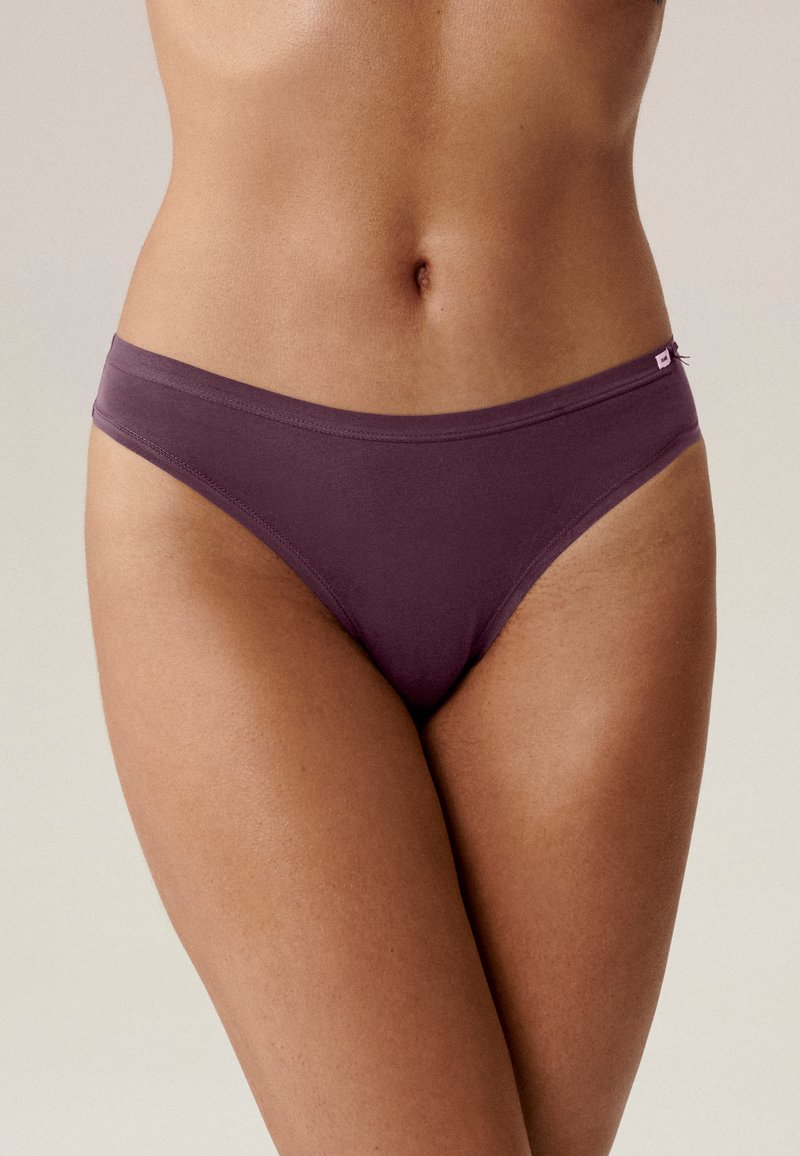 Fioletowy bikini z mikrofibry o gładkiej fakturze, niskim kroju i cienkim pasku, z małą metką logo z boku.