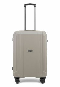 Hartschalenkoffer in hellbeige, mit strukturierten Oberflächen, vier Rädern, einem teleskopischen Griff und einem Emblem auf der Vorderseite.