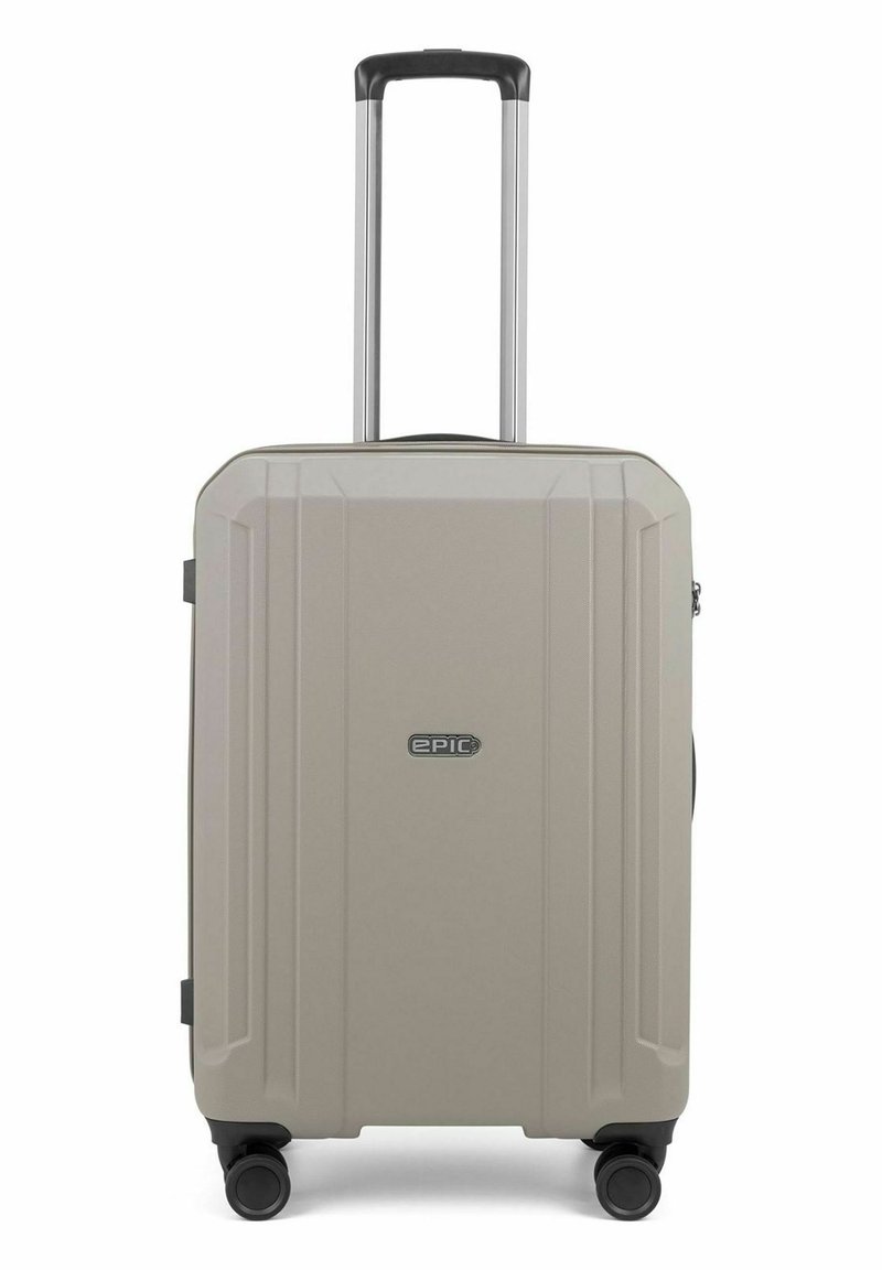 Hartschalenkoffer in hellbeige, mit strukturierten Oberflächen, vier Rädern, einem teleskopischen Griff und einem Emblem auf der Vorderseite.
