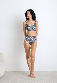 Bikini-set med leopardmønster som har en bralette topp med v-hals og høy midje-bunn, laget av lett stoff.