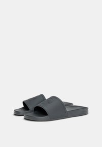 Grå gummiflip-flops med ett texturerat rem och logodetalj. Platt sula och öppen tådesign som är lämplig för avslappnad användning.