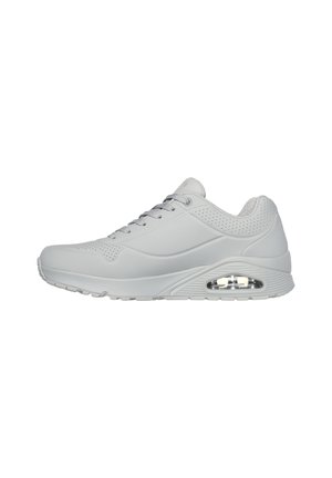 Light gray athletic shoe with a smooth synthetic upper, perforated details, lace-up closure, and visible air cushioning in the sole.