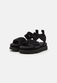 Zwarte sandalen met klittenbandsluitingen, een dikke, gewatteerde zool en een textuur van suede. Open teenontwerp met een comfortabele pasvorm.