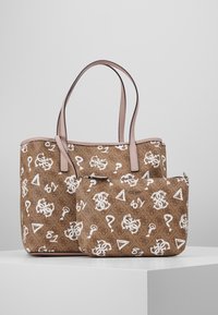 Sac cabas marron et pochette assortie avec des symboles et logos blancs, avec des poignées et un liseré roses sur un fond clair uni.