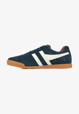 Dunkelblaue Wildleder-Sneaker mit weißen diagonalen Streifen, Gummisohle, runder Spitze und strukturierten Details auf der Oberfläche.