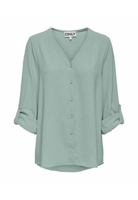 Blouse vert clair à manches longues, col en V, boutons recouverts de tissu sur le devant, manches retroussées fixées par des pattes à boutons.