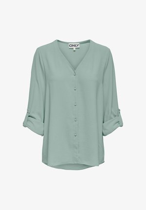 Hele-roheline heledam pikaaegsete varrukatega pluus V-kaelusega, kangaskattega nööpidega esiküljel ja üles rullitud varrukatega, mis on kinnitatud nööbitavate aasadega.