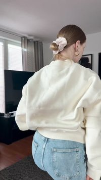 Valge lühikeste varrukatega sviitri ühelt pehmest kangast, millel on soonikkoes kubukad ja kaelus. Kombineeritud helesiniste kõrge vöökohtadega teksadega.