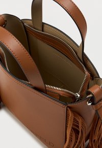 Bolsa de couro castanho com um design estruturado, alças duplas no topo, bolso interior com fecho e detalhes em franjas ao longo do lado.